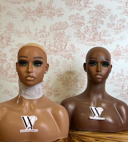 Two mannequin heads with 'W Fitness World' logo against a patterned wall.